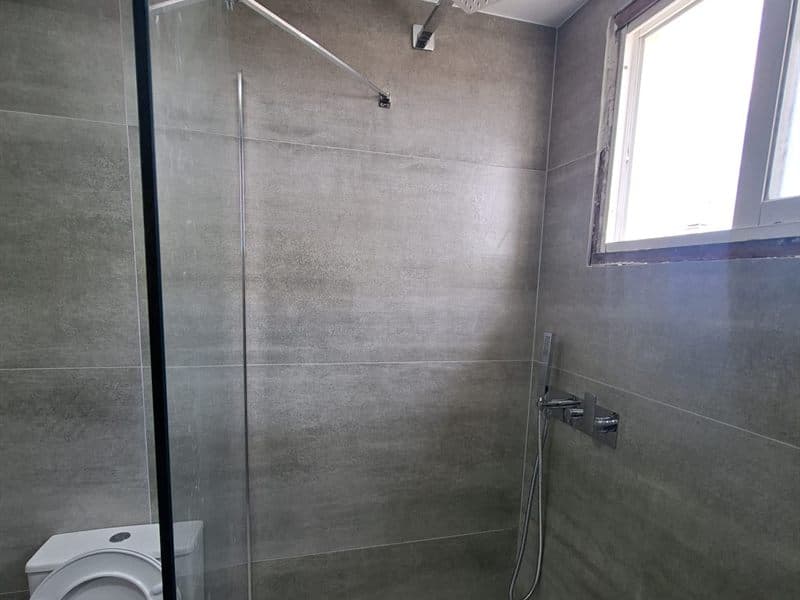 Ducha con paredes alicatadas en una reforma de baño en Vigo