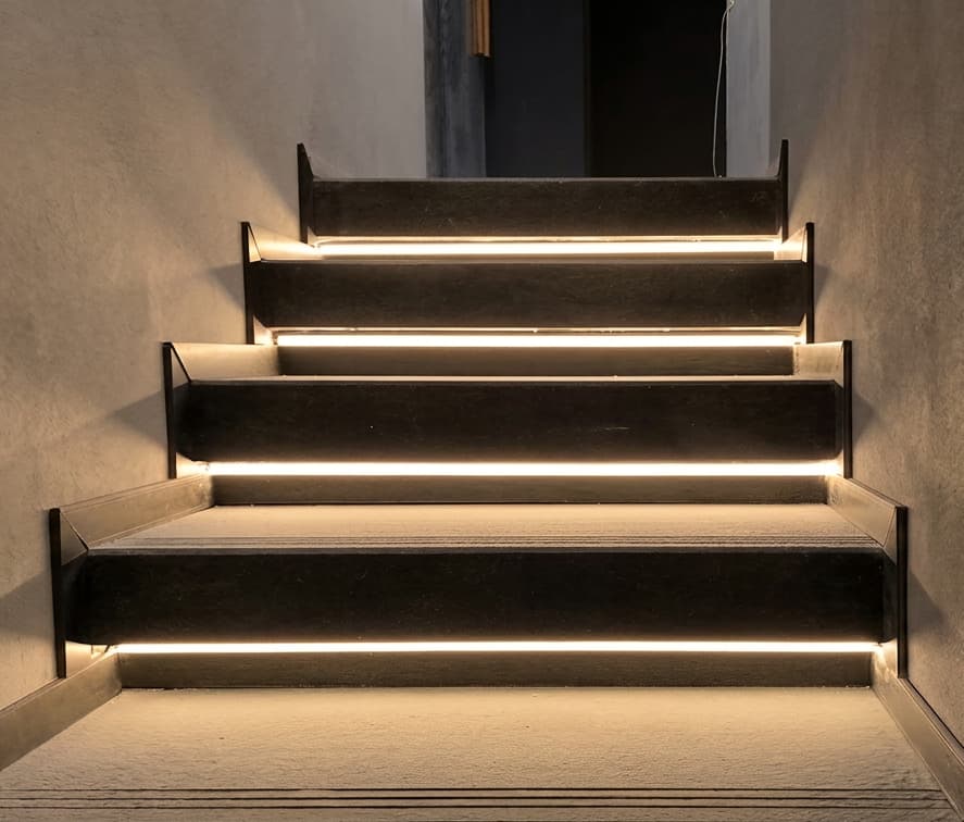Escalera interior reformada con iluminación LED en los peldaños en Vigo