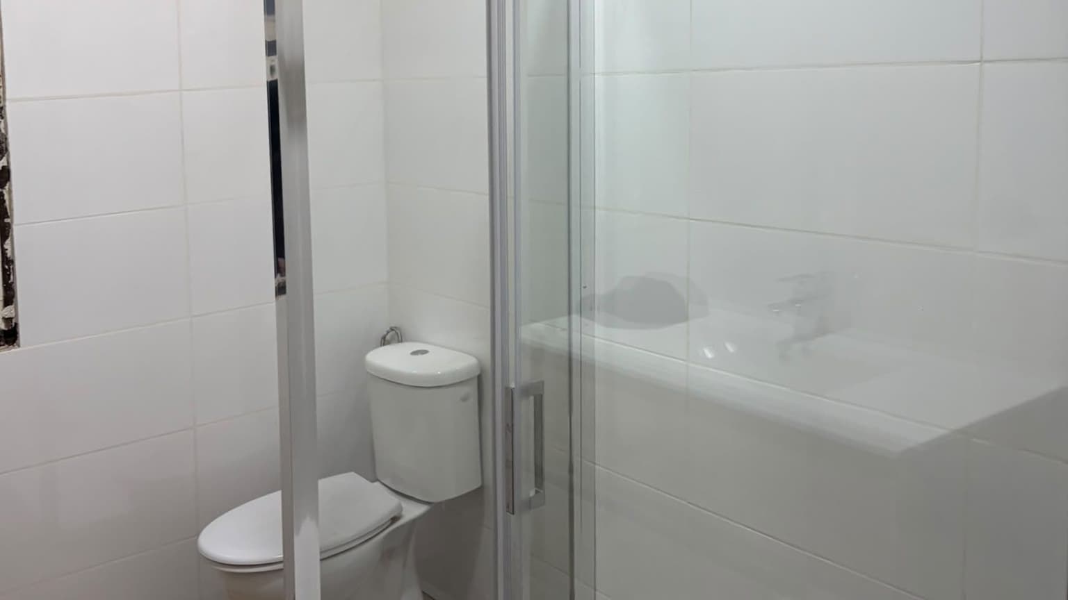 Baño reformado con ducha de obra y mampara de cristal en Vigo